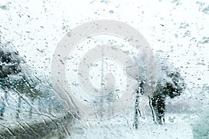 View from the car window on the snow-covered track. Road view through car window during snowfall.