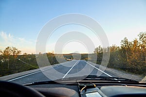 View from car windscreen to highway and tundra in evening time