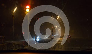 View through car windshield to night road with moving cars.