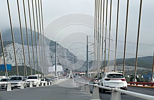View of cars on modern bridge near mountain photo