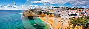 View of Carvoeiro fishing village with beautiful beach, Algarve, Portugal. View of beach in Carvoeiro town with colorful houses on photo