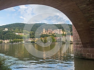 View of a castle through the arch of a bridge