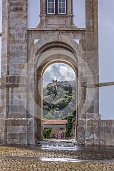 View of the castle and fortress of obidos, between arches pillars of Lord Jesus of the Stone Sanctuary