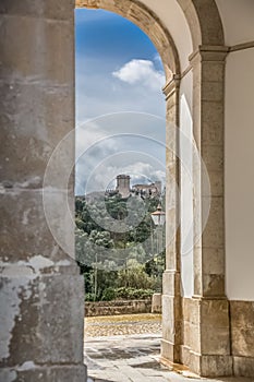 View of the castle and fortress of Obidos, between arches pillars of Lord Jesus of the Stone Sanctuary