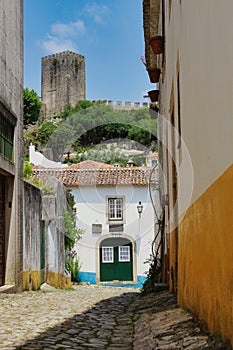 View of the castle from a street in the town of Obidos, Portugal.