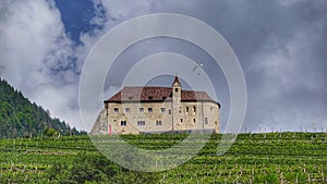 View of Castle Tirol in Tirolo with a paraglider above the roof