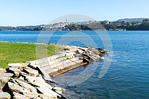 View of Castropol in Asturias across the Ribadeo River with the Praia dos Bloques in the foreground photo