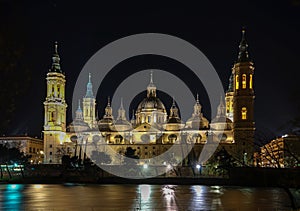 View of Cathedral Basilica of Our Lady of The Pillar at night with reflections on Ebro River in Zaragoza, Spain