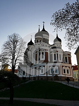 View of the Cathedral of the Holy Prince Alexander Nevsky against the blue sky and the Commandant`s Garden with paths and trees
