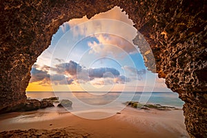 View from the cave a sandy beach along the ocean at sunset