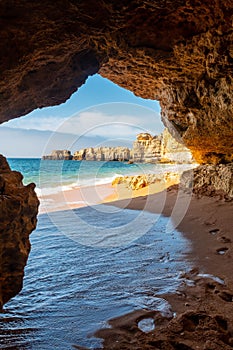 View from cave to beach surrounded by cliffs at beach Coelha