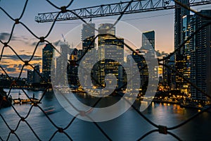 View through chain link of modern city