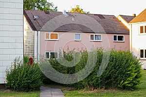 View of cheap residential building exterior with windows in Germany with lawn yard. No people.