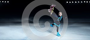 View of child  figure skater on dark ice arena