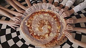 View of children`s fingers moving synchronously and fast to pizza in a centre