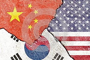 View of China USA South Korea flags icon on weathered cracked wall background