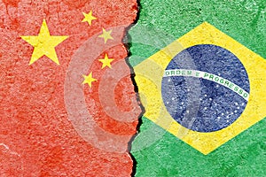 View of China VS Braz national flags isolated on broken cracked concrete wall background photo