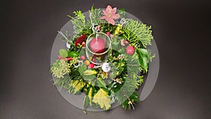 View of a Christmas wreath, candles and various decorations on a dark background