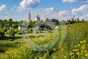 View of the church of Boris and Gleb and urban development on the background of yellow grass