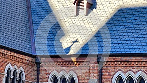 View of a church cross shadow on the roof of a medieval building
