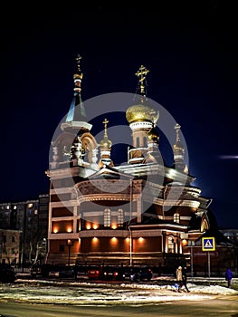 view of the church on a frosty winter night, the domes shine gold in the dark night sky