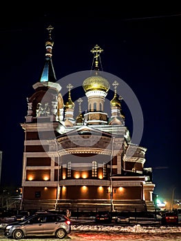 view of the church on a frosty winter night, the domes shine gold in the dark night sky