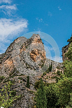 View of the church Notre-Dame de Beauvoir amid the cliffs and steeple of Moustiers-Sainte-Marie.
