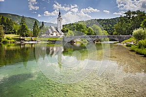 View of the Church of St. John the Baptist on the banks of the Sava river near Lake Bohinj in Slovenia