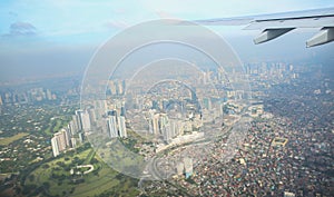 A view of the city of Manila through the window from the plane. Impressed photo of a tourist in flight over the capital