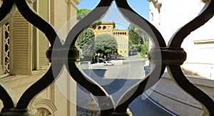 View of the city through the openwork metal fence in Rome