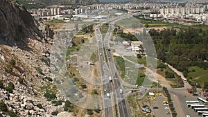 The view of the city and the road cars with the high mountains or the cable car.