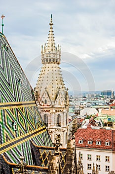 View of city from St. Stephen`s Cathedral. Famous ornately patterned, multi colored roof and north tower, Vienna, Austria