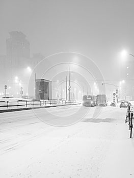 View of a city street in the evening during heavy snowfall.