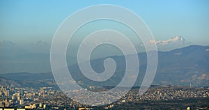 View of the city of Tbilisi and Rustavi with mount Kazbek in the morning haze against the blue sky on the backgroundi