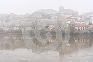 View of the city of Zamora with San Isidoro church and the Douro river in a foogy day photo