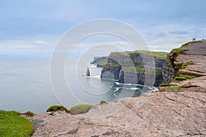 View on Cliff of Moher, county Clare, Ireland.Silhoette of couple of tourists. Epic landscape with magnificent scenery. Irish