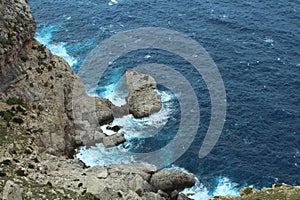 View from the cliff on the waves breaking on the shore. Cape Formentor. Majorca. Spain