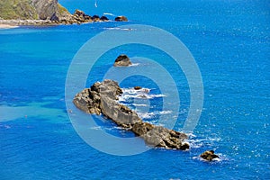 View of the cliffs and blue sea on a sunny day. Lulworth Cove, Dorset, England, UK.