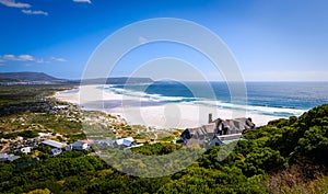 A view looking down at the beautiful white sand beach of noordhoek in the capetown area of south africa. photo