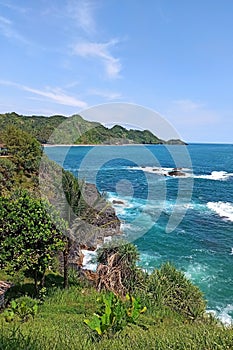 view of the cliffy beach with a blue sea background on the island of Bali photo