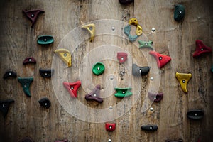 View of the climbing wall with colorful grips over a wooden structure