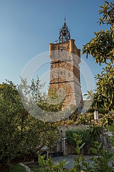 View of the clock tower made of stone on top of the hill with vegetation in Draguignan.