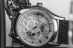 The view is close. Mechanism of a wristwatch. Gears, levers, springs and gems. Engraving and gold. old scratched glass, broken.