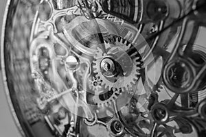 The view is close. Mechanism of a wristwatch. Gears, levers, springs and gems. Engraving and gold. old scratched glass. Concept of