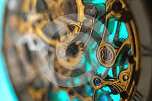 The view is close. Mechanism of a wristwatch. Gears, levers, springs and gems. Engraving and gold. old scratched glass. Concept of