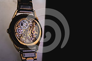 The view is close. Mechanism of a wristwatch. Gears, levers, springs and gems. Engraving and gold. old scratched glass. Concept of