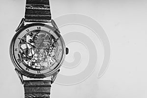 The view is close. Mechanism of a wristwatch. Gears, levers, springs and gems. Engraving and gold. old scratched glass. Concept of