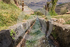 View close-up on a water canal of the ancient Inca ruins TipÃ³n, Peru.