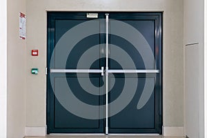 View of the closed door of the evacuation exit from the building during a fire or other cataclysm. Emergency fire exit from the