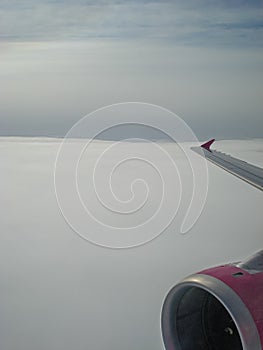 View of the clouds through the airplane window. Wing and turbine of a flying aircraft. The sky and the cloud. Travel  flight to